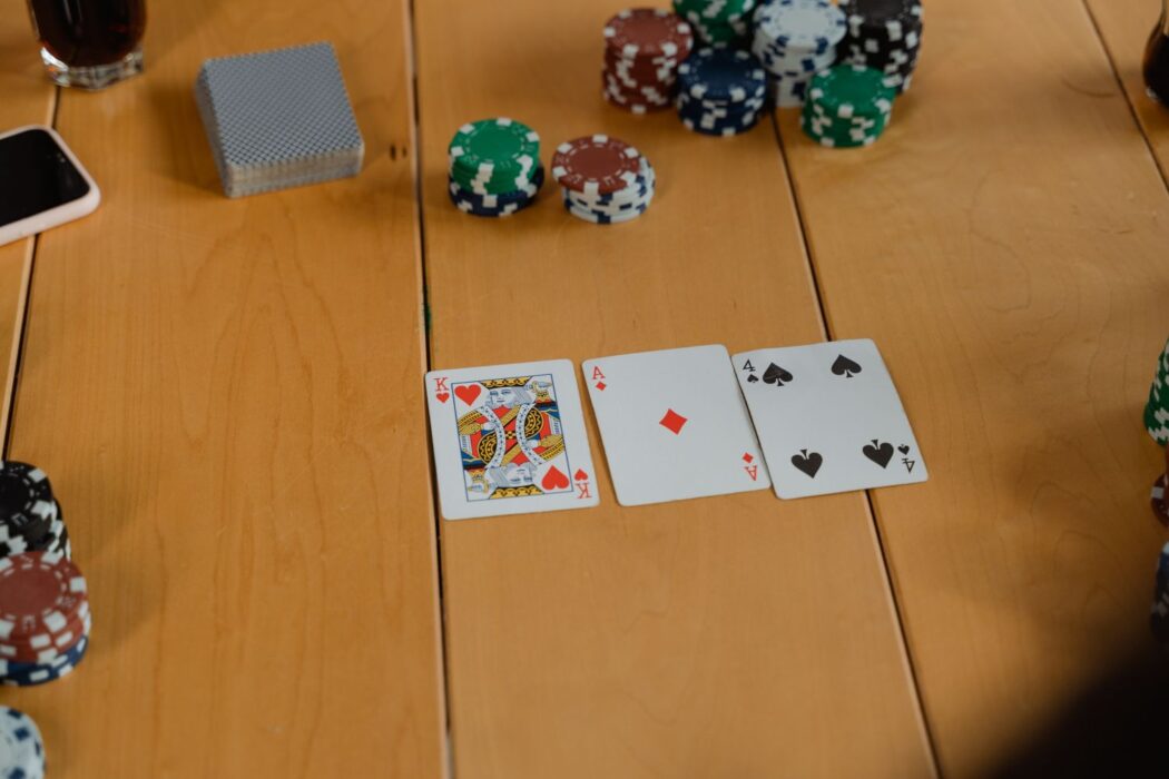 Cartes à jouer et jetons colorés sur une table en bois, variantes poker