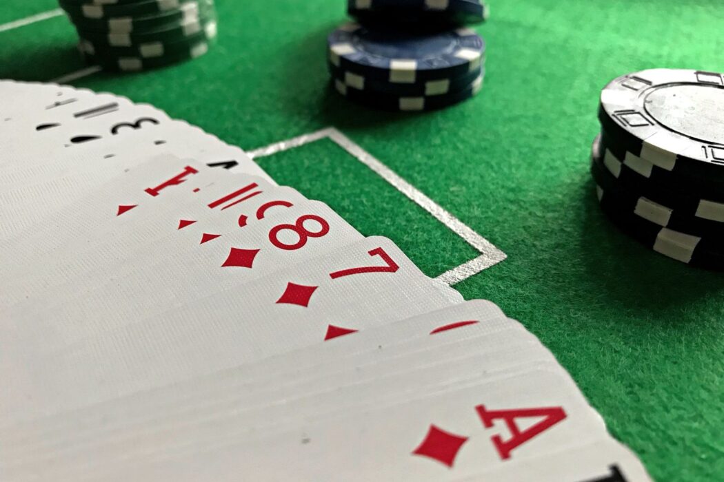 Cartes de poker et jetons en gros plan sur tapis vert, cash game ou tournoi