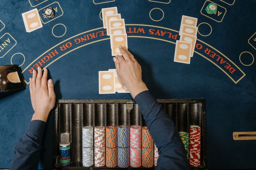Croupier distribuant des cartes sur une table de blackjack avec jetons visibles