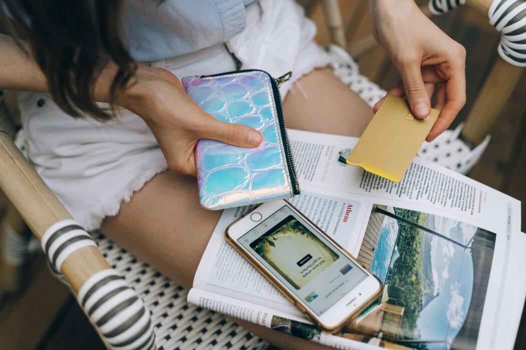 Femme assise dehors utilisant smartphone et carte bancaire pour parier