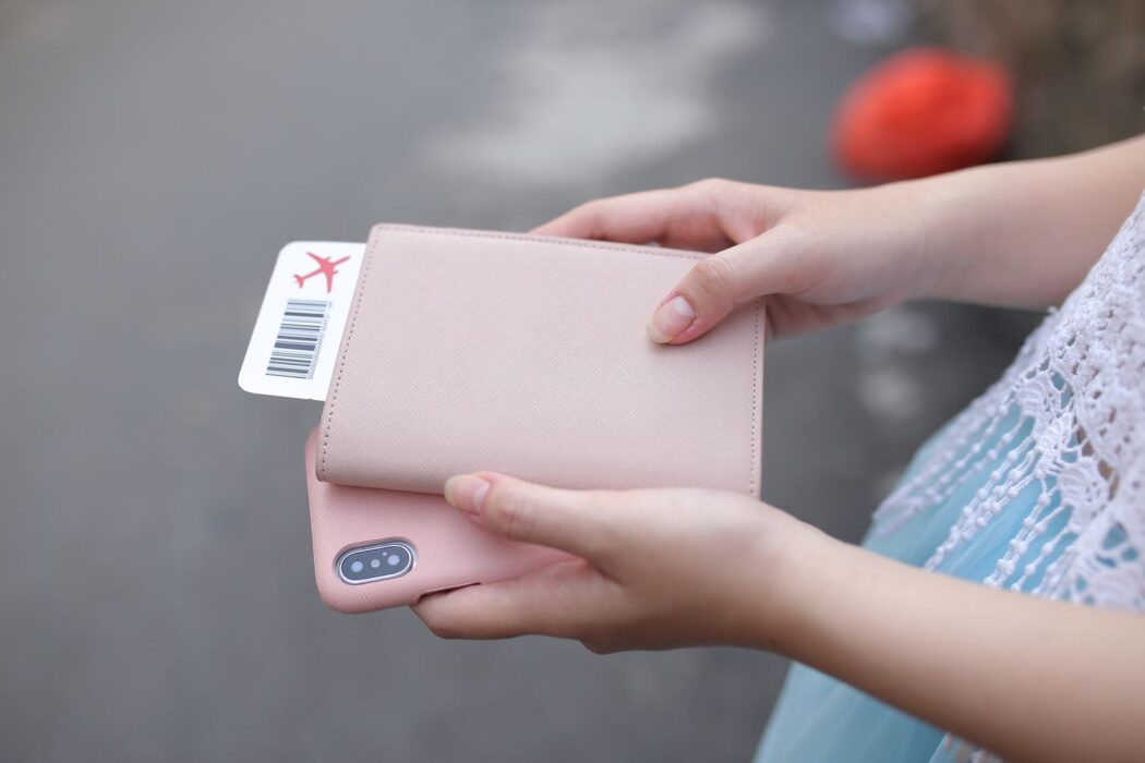 Femme tenant passeport, carte d'embarquement et smartphone avant de voyager