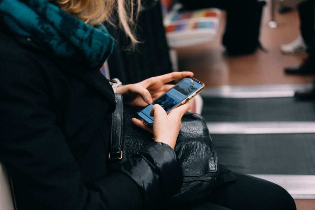 Femme utilisant son smartphone dans les transports en commun pour jouer au casino mobile