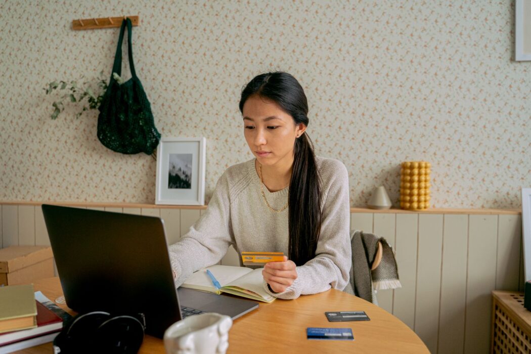 Femme utilisant un ordinateur portable et une carte bancaire pour un nouveau casino