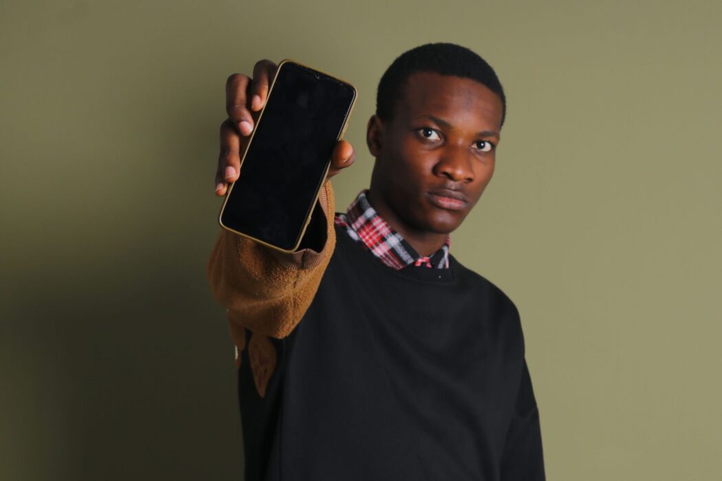 Homme tenant fièrement un smartphone, connexion internet pour casino en ligne