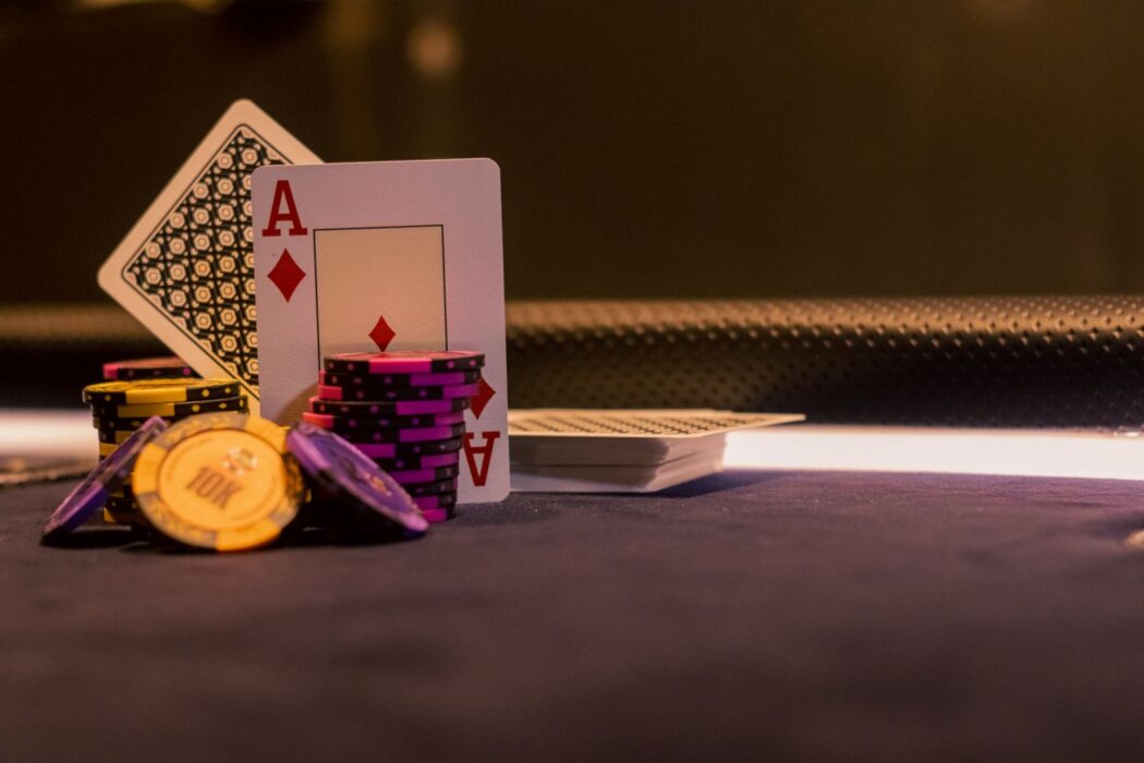 Jetons de poker et cartes sur table de jeu, as de carreau visible
