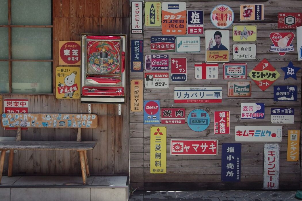 Machine pachinko vintage entourée d'enseignes japonaises anciennes, ancêtre du Plinko