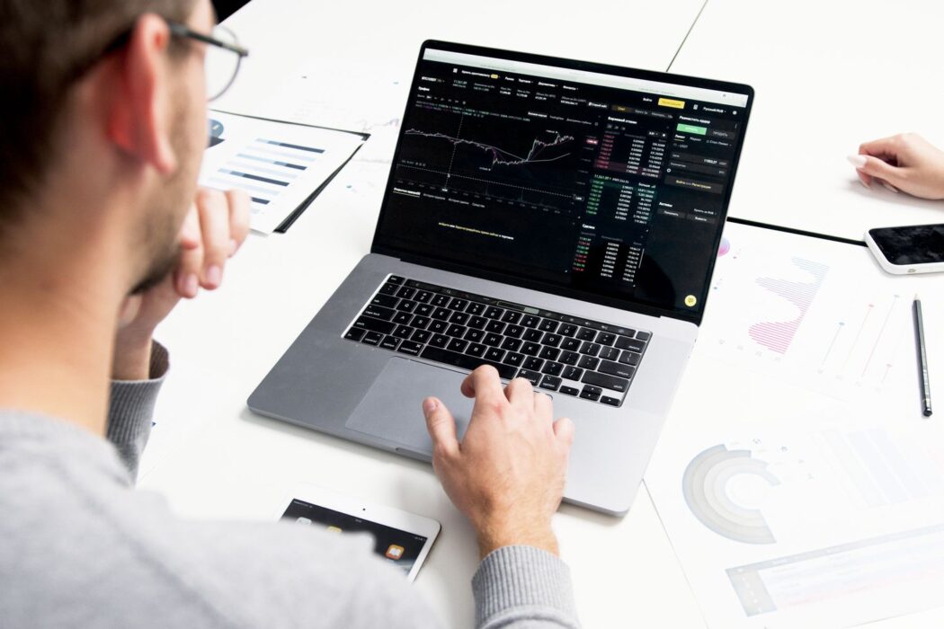 Professionnel analysant des données financières sur un ordinateur portable pour un pronostic
