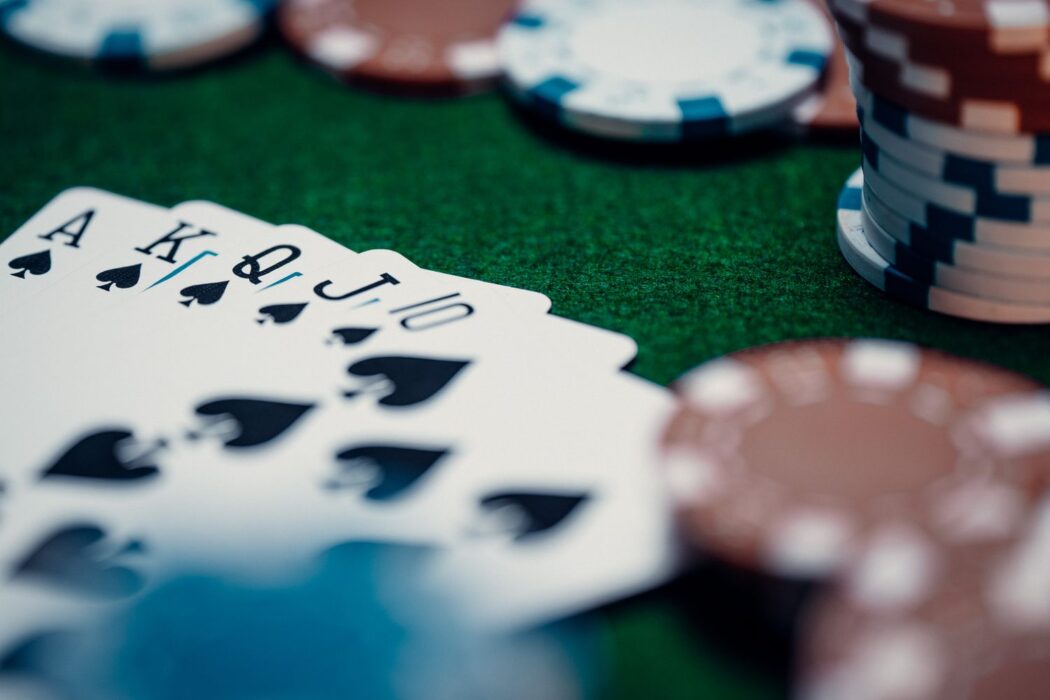 Quinte flush royale et jetons colorés sur table verte de casino