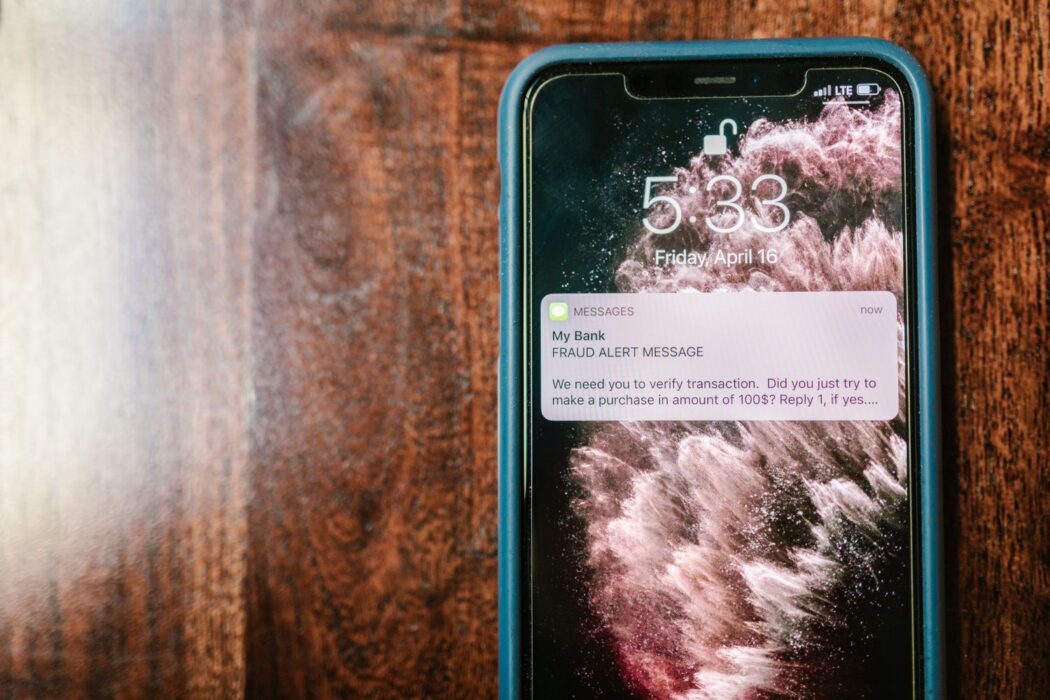 Smartphone affichant une alerte de sécurité sur une surface en bois, paiement Visa