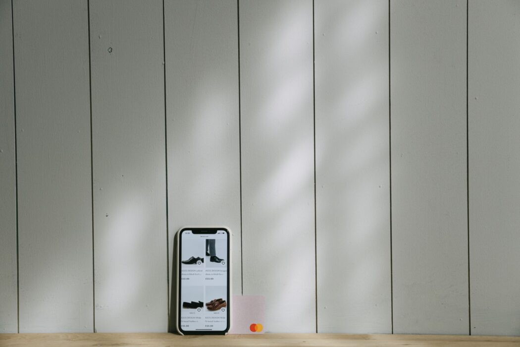 Smartphone et carte bancaire virtuelle posés sur une surface en bois, éclairage doux