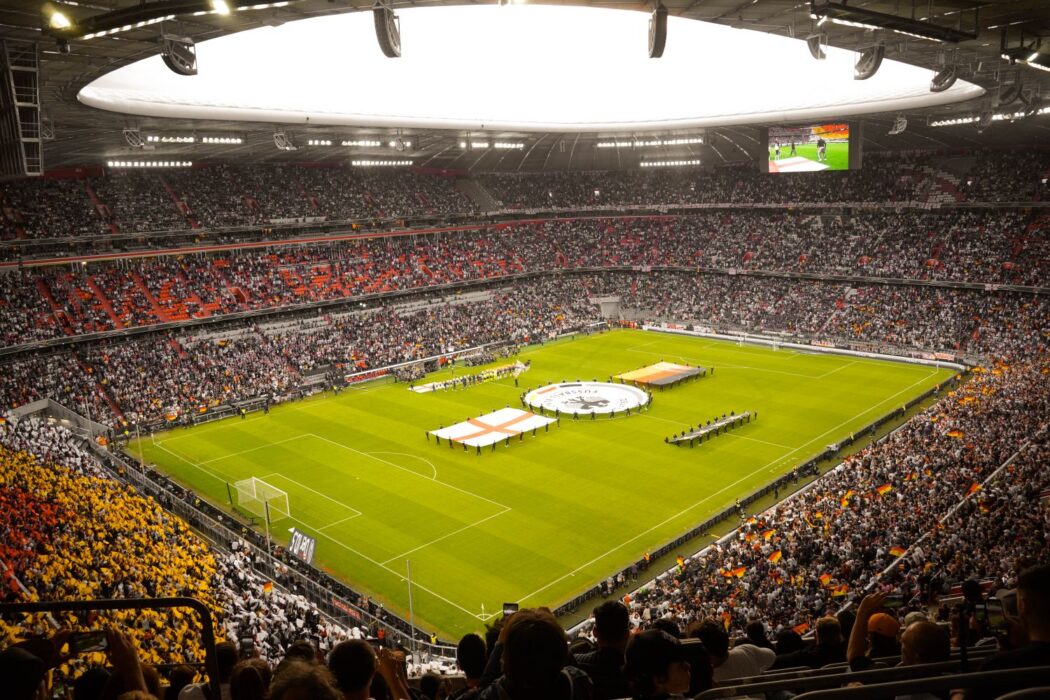 Stade rempli de supporters aux couleurs vives lors d'un match de football en direct