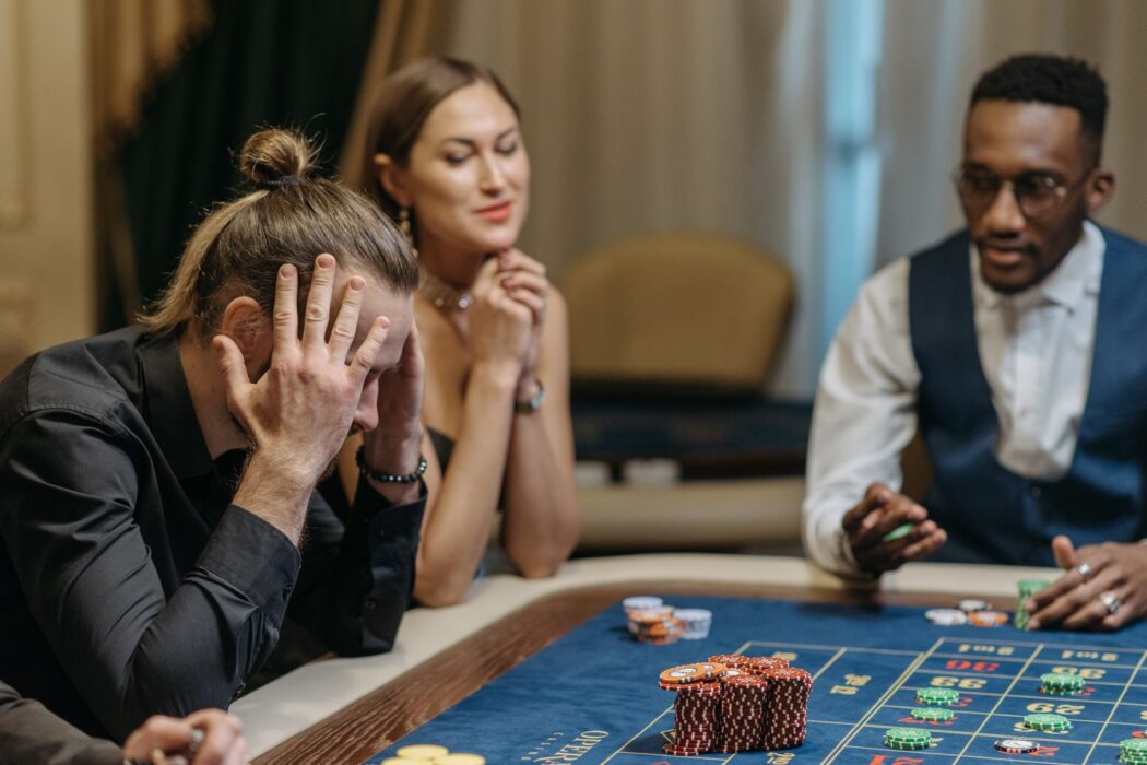 Trois joueurs autour d'une table de roulette de casino pour parier