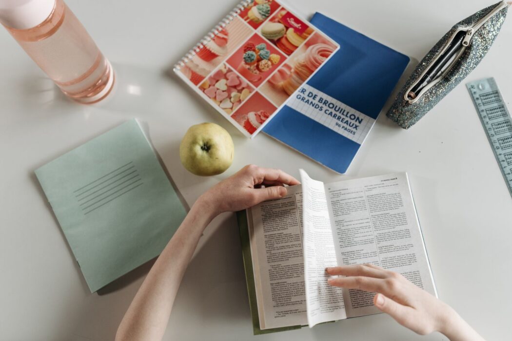 Vue de dessus de mains tournant les pages d'un livre pour parier